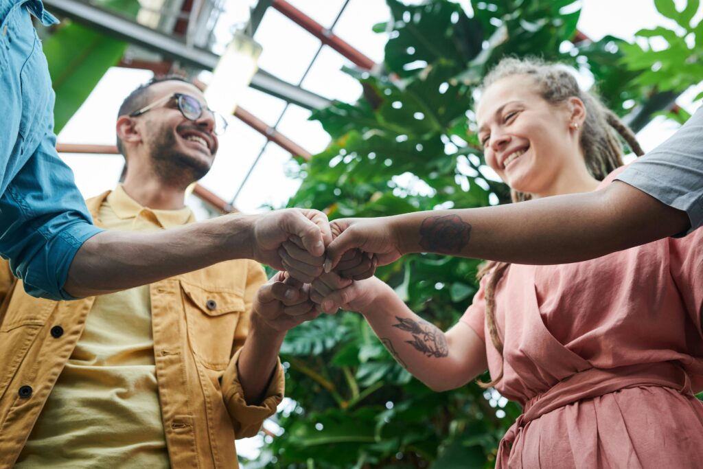 Three people smiling and fist-bumping together.